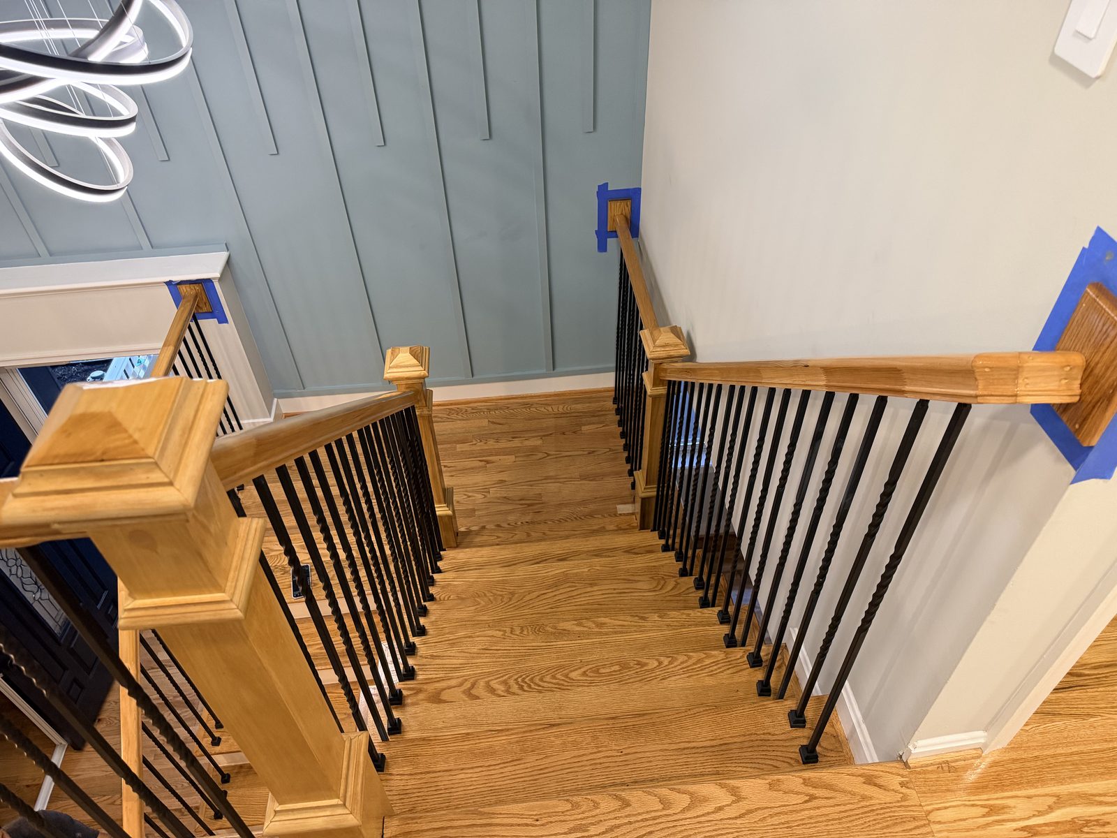Top-down view of a red oak staircase and landing during refinishing