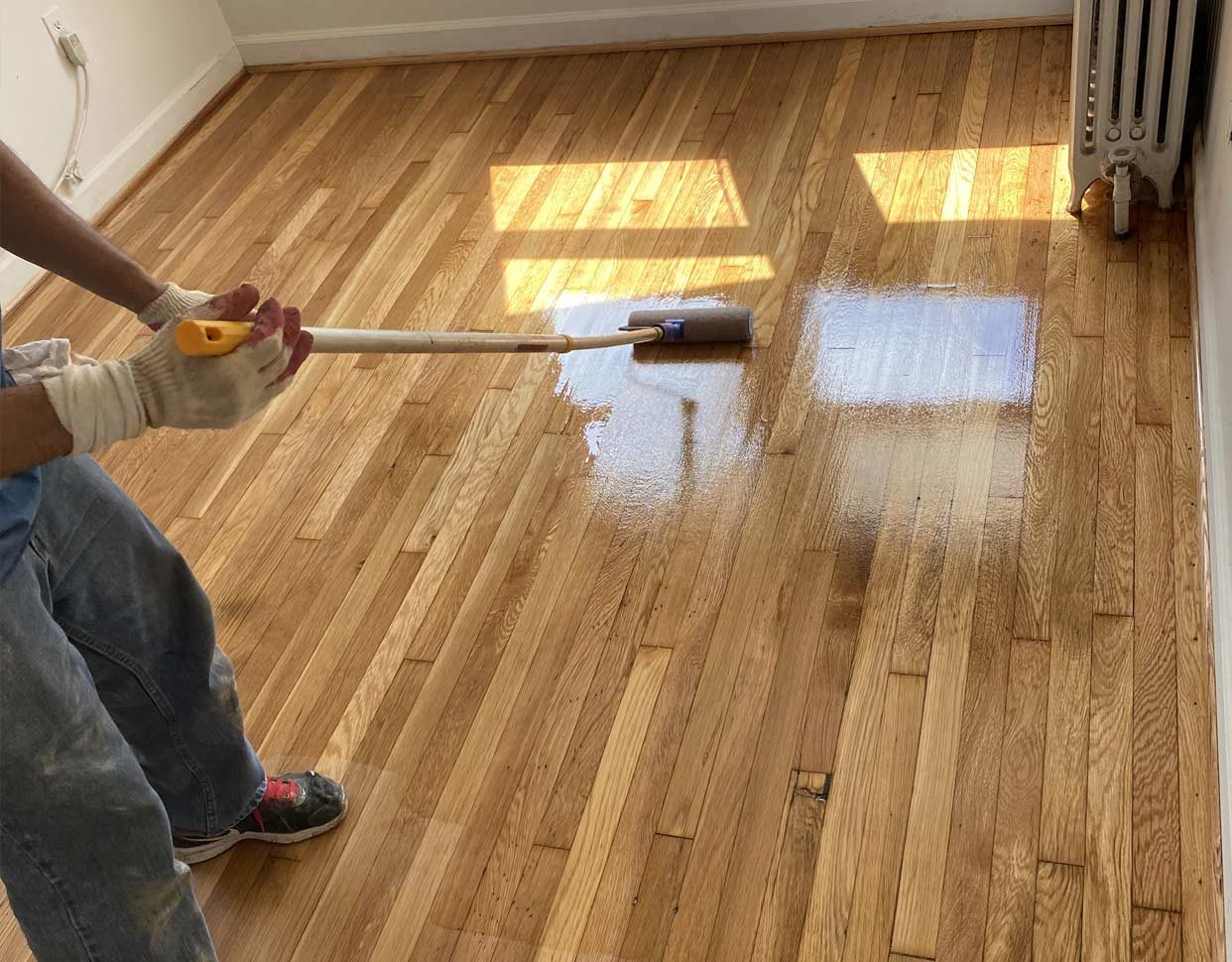 Applying finish to a hardwood floor with a lambswool applicator