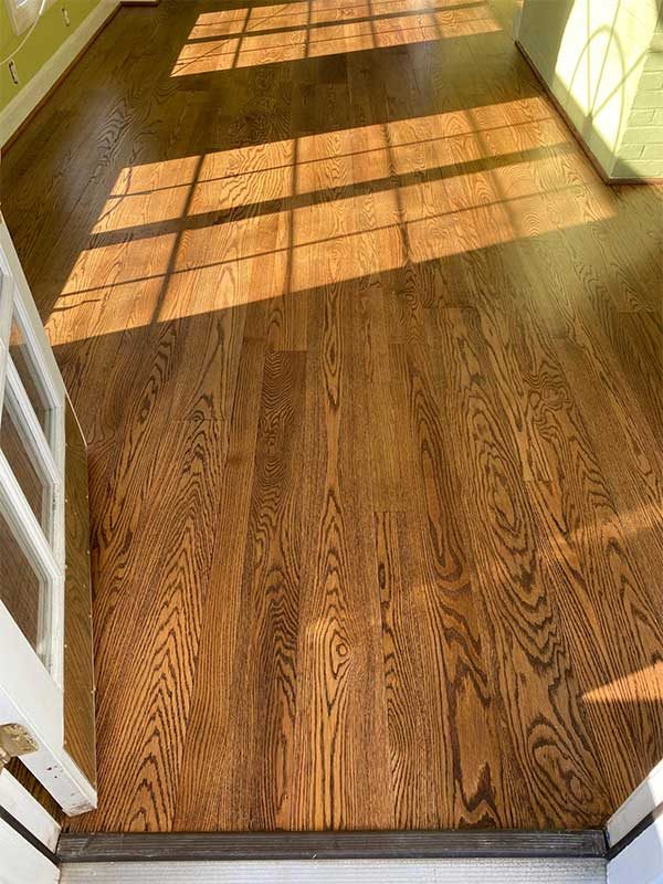 Refinished red oak hardwood floor in a sunlit Bethesda, MD home