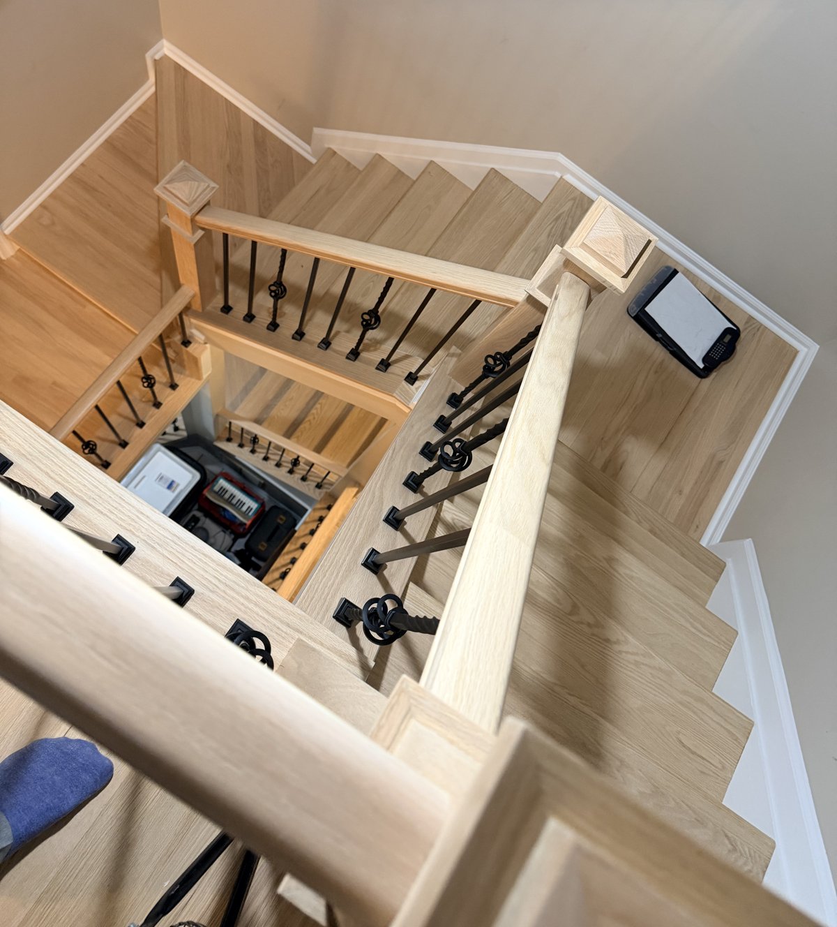 Hardwood staircase with black iron balusters refinished with Bona Nordic finish for a light natural look in Columbia, MD