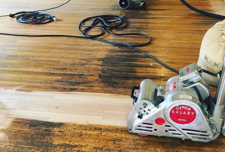 Floor sander working on an old hardwood floor