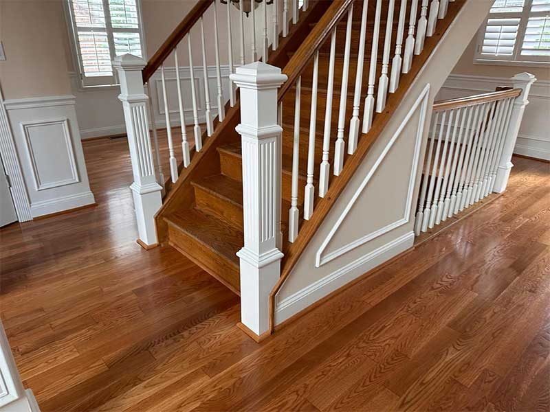 Refinished staircase with white balusters and wood handrail in Maryland