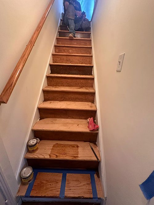 Narrow stairway with refinished oak treads and wood handrail