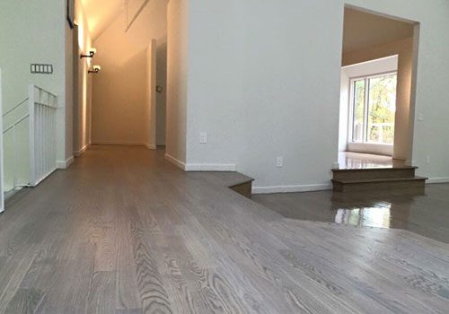 Resurfaced gray-toned hardwood floor in a hallway