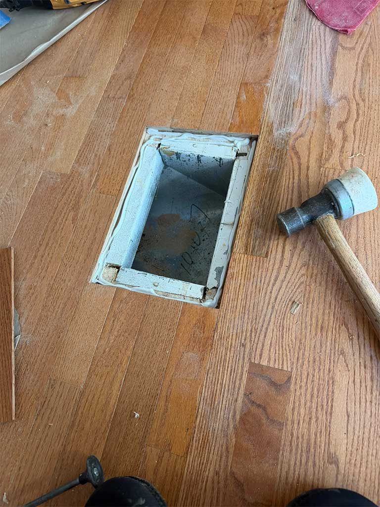 Flush vent being installed in a hardwood floor in Silver Spring, MD